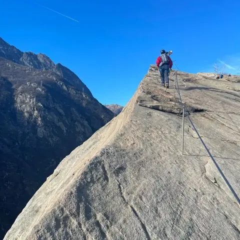 Escursionista su una placca di roccia attrezzata
