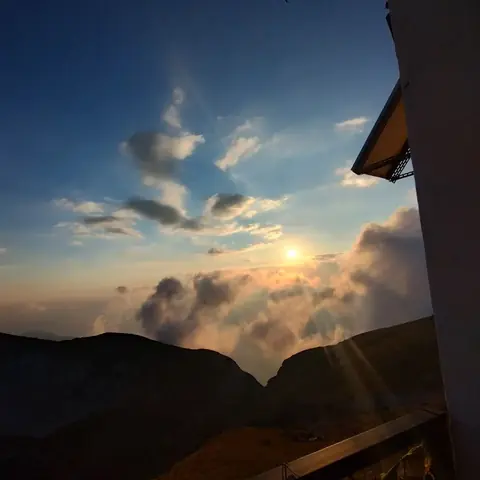 Tramonto tra le nuvole visto da un rifugio