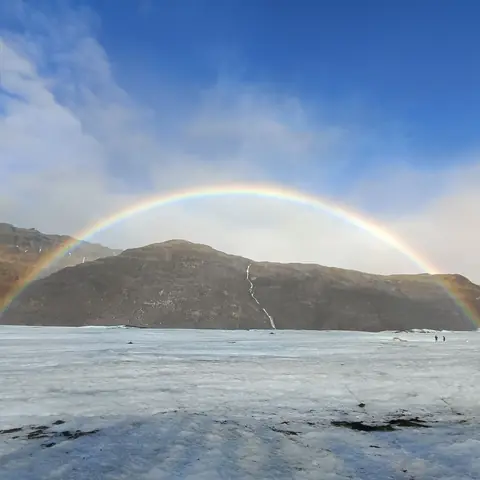 Arcobaleno sopra il ghiacciaio e le montagne in Islanda