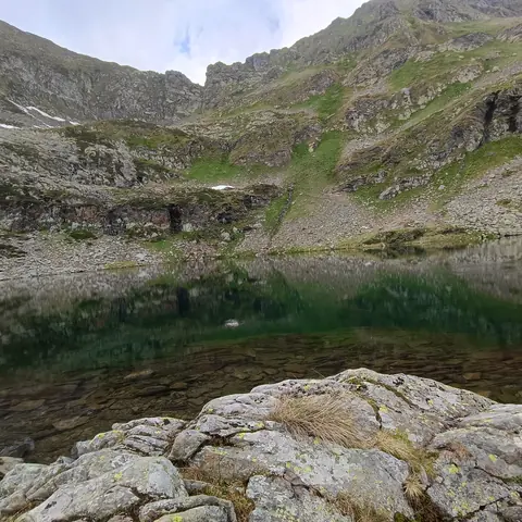 Laghetto alpino tra le rocce e i prati